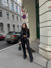 a lady wears a black tweed jacket with black wide leg pant